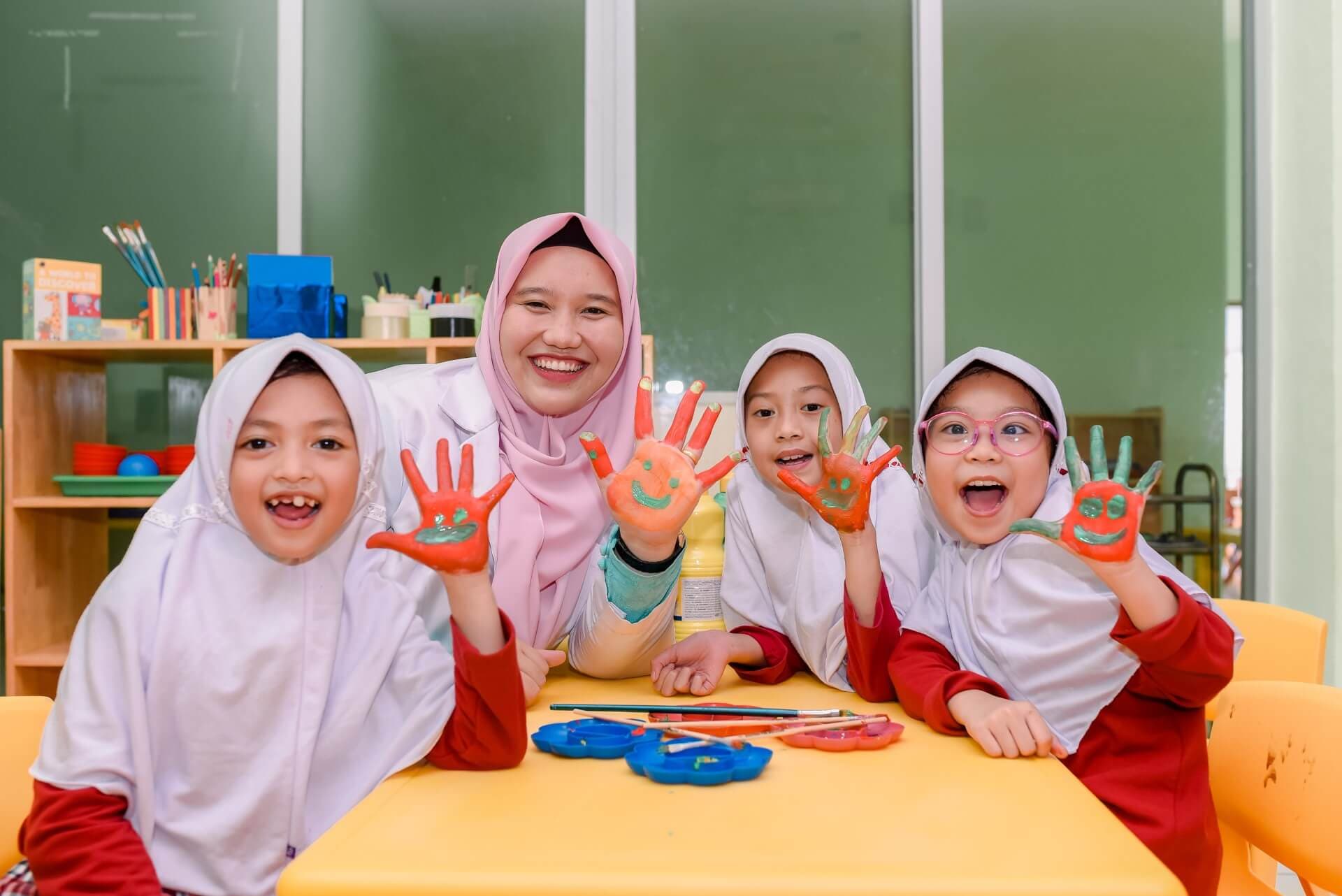 A Prestige teacher and her pupils showing off palms covered in colourful paint